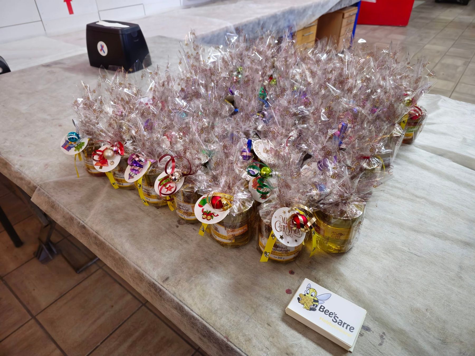 Verpackte Honiggläser mit Weihnachtsschmuck auf einem Tisch bei der Feuerwehr